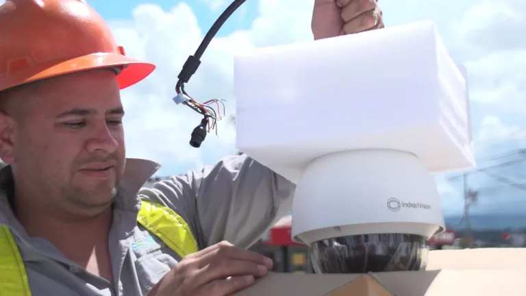 Cámara tipo domo permite la visión en 360 grados Hombre con casco naranja instalando una cámara de vigilancia