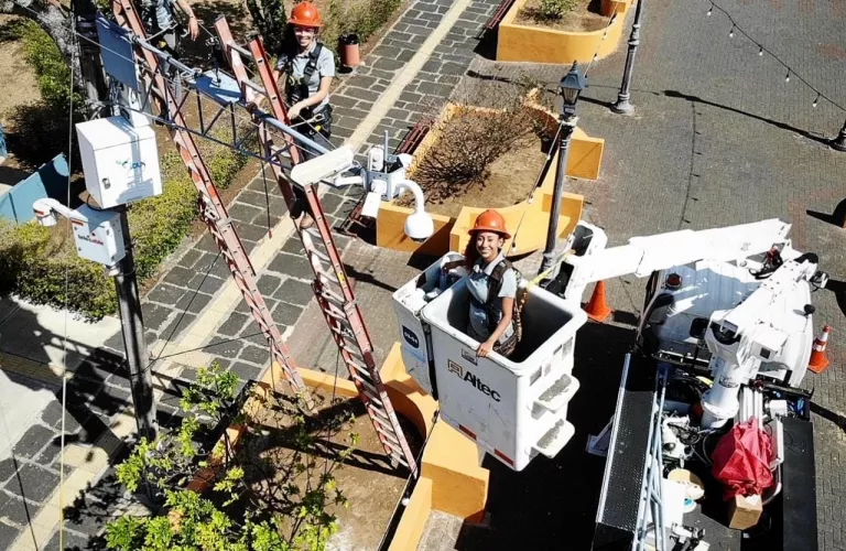 Tres técnicas trabajando en grúa en a calle