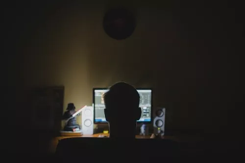 Sombra de la cabeza de una persona desde atrás con un monitor de computadora al fondo