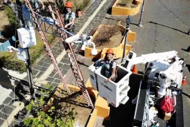 Tres técnicas trabajando en grúa en a calle
